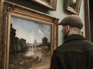 Visiteur devant un tableau ancien dans une galerie d'art